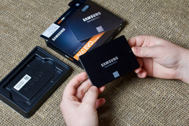 MINSK, BELARUS - NOVEMBER 25, 2019: A man takes out a package of Samsung 860 Evo 500GB SSD Hard Drive. MINSK, BELARUS - NOVEMBER 25, 2019: A man takes out a package of Samsung 860 Evo 500GB SSD Hard Drive. spatholobus suberectus dunn photos stock pictures, royalty-free photos & images
