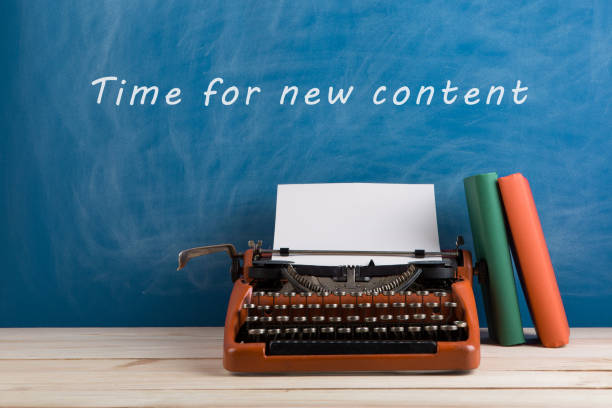 istock writer's workplace - red typewriter and stationery on blue blackboard background with text 