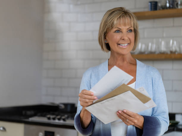 istock Retired woman checking the mail and looking happy 1189981539
