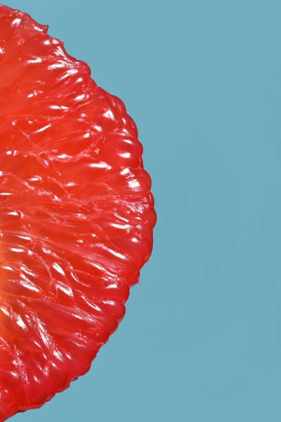 Peeled Slice Of Juicy Grapefruit on Blue Background stock photo