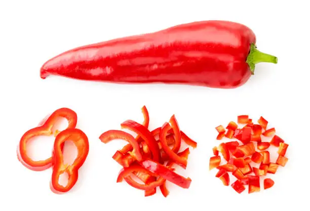 Sweet red pepper and three piles of sliced pieces, set on a white background. The view of the top.