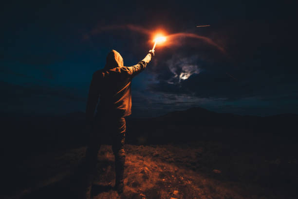 istock The male with a firework stick standing on a night mountain 1189983626