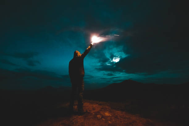 istock The man with a firework stick standing on the night mountains 1189983727