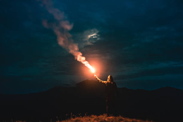 The man standing with firework stick on the mountain