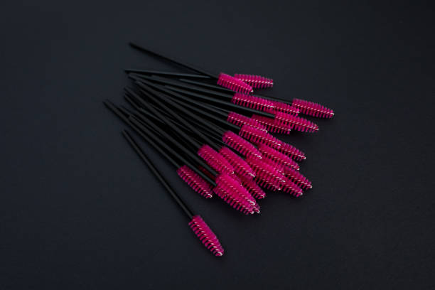 istock Pink mascara brushes on black background 1189985397
