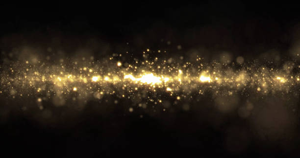istock Gold glitter, sparkling bokeh light wave flow. Golden glittering light sparks, magic shimmering glow 1189986586