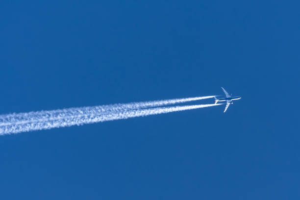 airplanes leaving contrail trace on a clear blue sky. - rasto de fumo de avião imagens e fotografias de stock