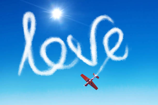 надпись в небе - любовь, оставленная белым дымом из самолета. - skywriting стоковые фото и изображения