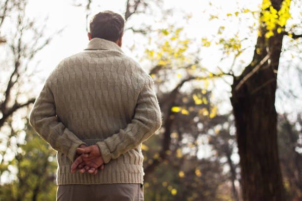Senior man walking and relaxing in park. Walking away, relaxing, rear view