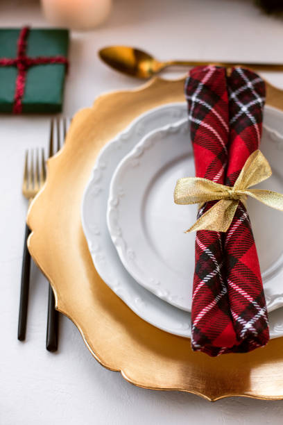 istock Empty gold and white plates with red napkin for Christmas dinner. 1189989880