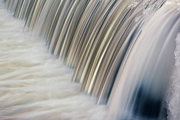 Winter landscape of the Portage Creek cascade framed by ice and captured with motion blur, Michigan, USA