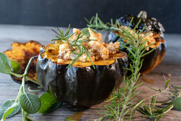 Baked acorn squash bowl with stuffing with rosemary and sage rustic stock photo