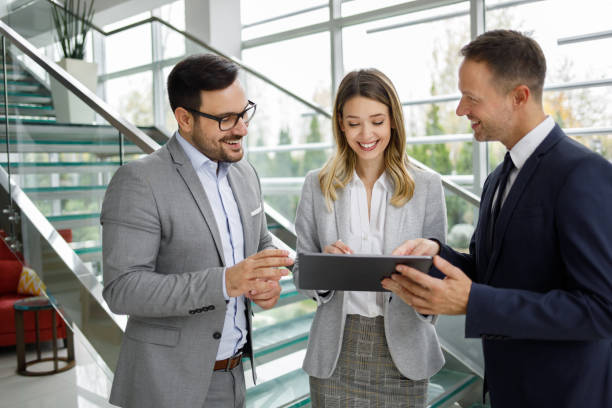 istock Business people discussing work over digital tablet in a lobby 1189993462