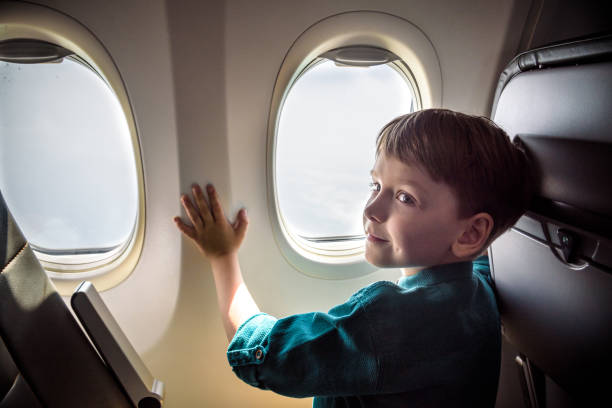 istock A boy have flight looking in the airplane window or porthole 1189995879