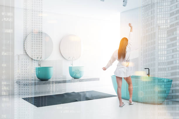 istock Woman in modern white and blue bathroom 1189996207