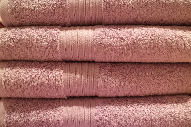 istock Front view of folded pink color fluffy bath towels stack 1189996339