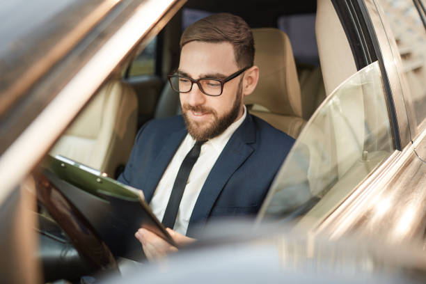 istock Businessman reading documents in the car 1189997416
