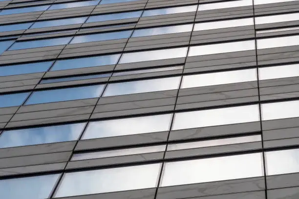 Cloud and sky are reflected in modern building wall.