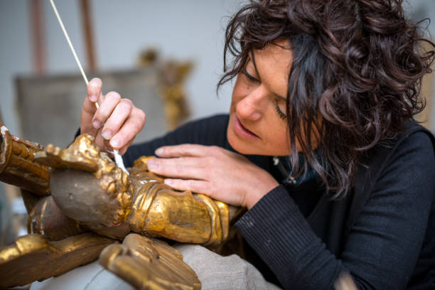 restorer and framer laboratory craftswomen: restoring antique golden angel statue - restoring art painting artist imagens e fotografias de stock