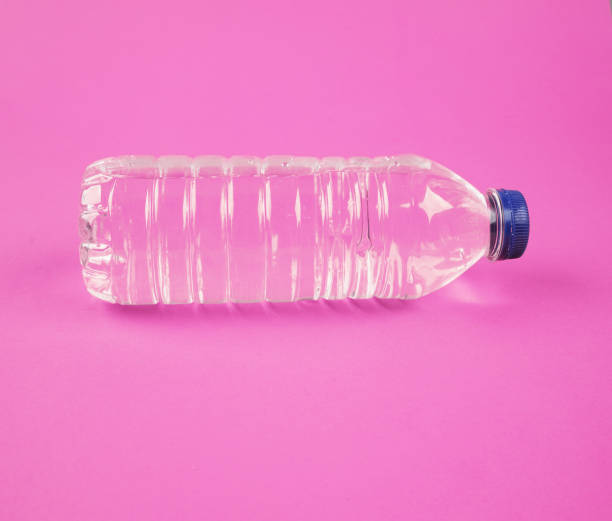 Water in plastic bottle on isolated pink background