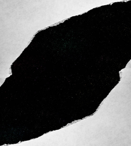 istock A hole in paper with torn edges close-up with a black background inside with colorful space stars in the universe. A hole in paper with a view of the cosmos of the universe. 1190003668