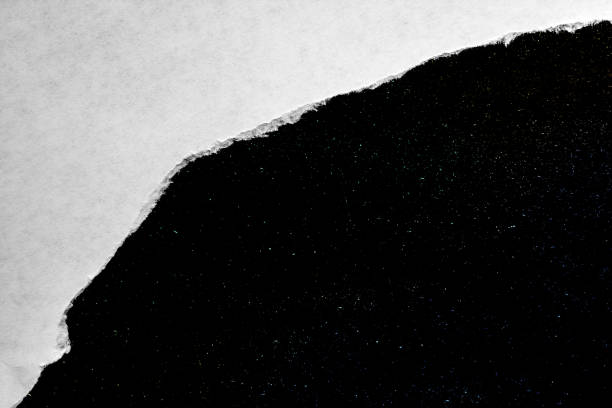 istock A hole in paper with torn edges close-up with a black background inside with colorful space stars in the universe. A hole in paper with a view of the cosmos of the universe. 1190003676