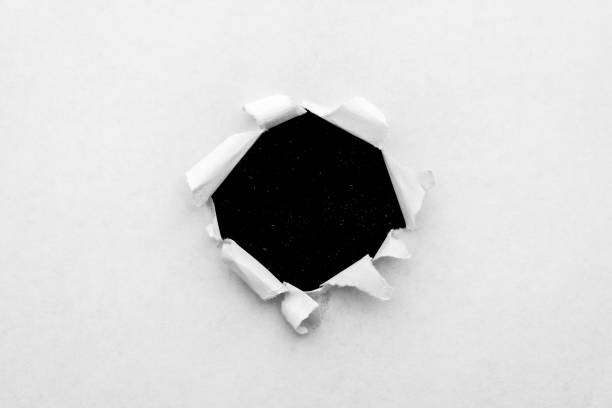istock A round hole in white paper with torn edges close-up with a black background inside with colorful space stars in the universe. A hole in paper with a view of the cosmos of the universe. 1190003807