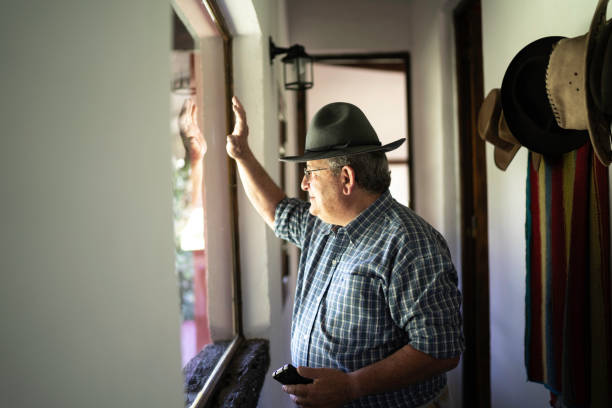 istock Senior man waving through the window 1190004294