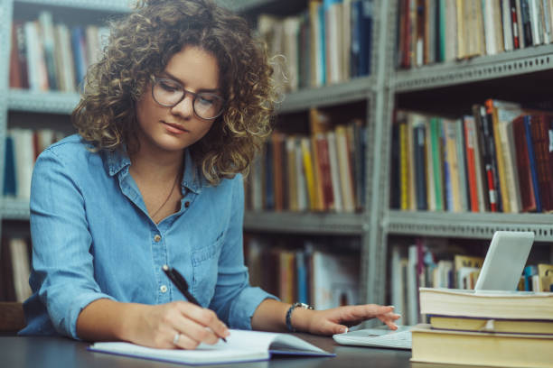 istock Young female student at the library. Young student 1190004312