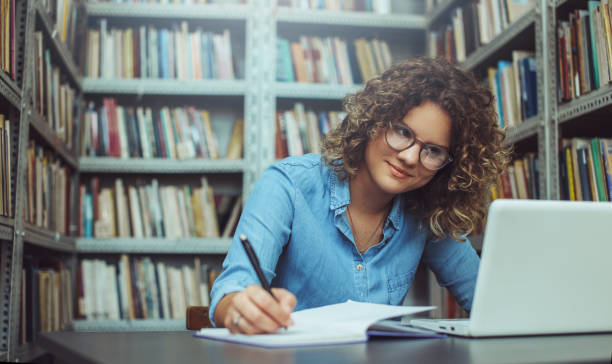 istock Young female student at the library. Young student 1190004905
