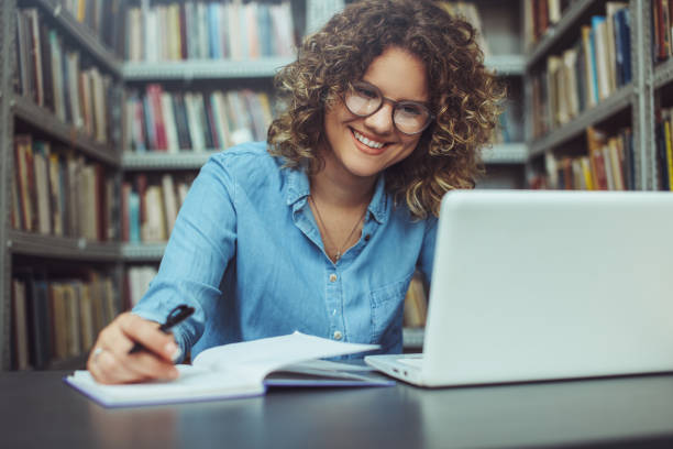 istock Young female student at the library. Young student 1190005023