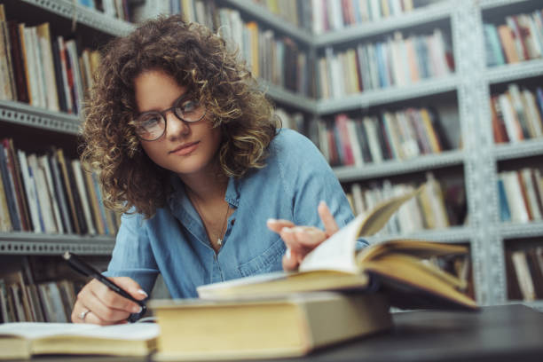 istock Young female student at the library. Young student 1190005048