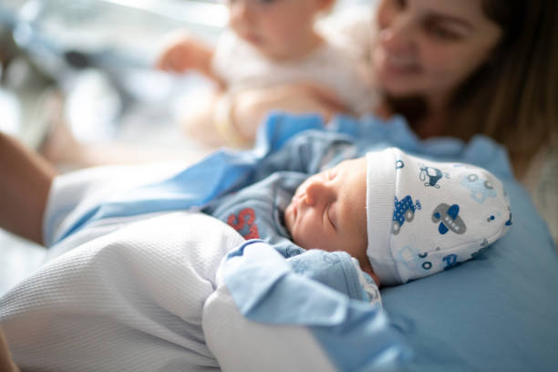 mother and sleeping newborn and son at hospital - women group of people lying down mother imagens e fotografias de stock