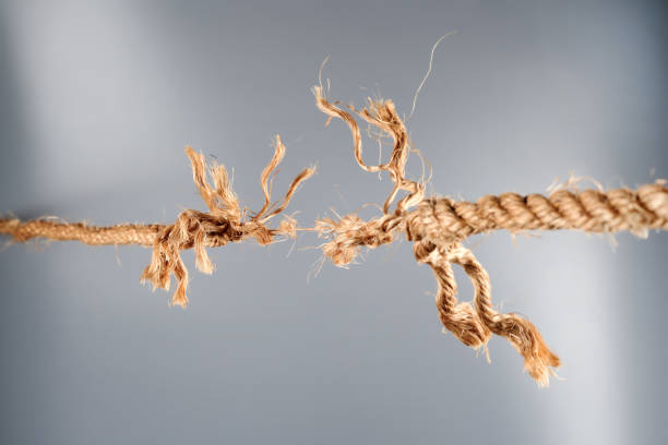 istock Frayed rope near to break on gray background 1190009776
