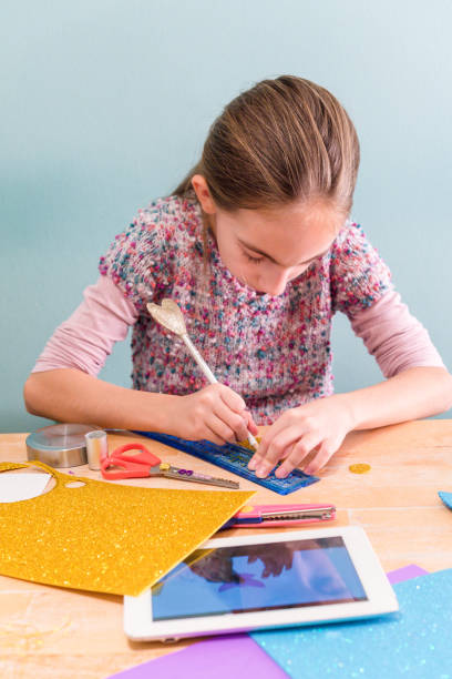 istock Young Girl Learning from Digital Tablet how to Make Decoration from Foam Rubber Sheet 1190009854