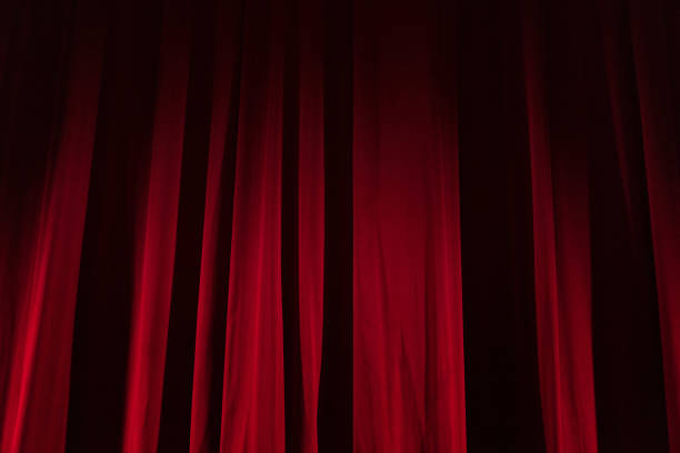 istock Theater red curtain with spot lighting 1190010016