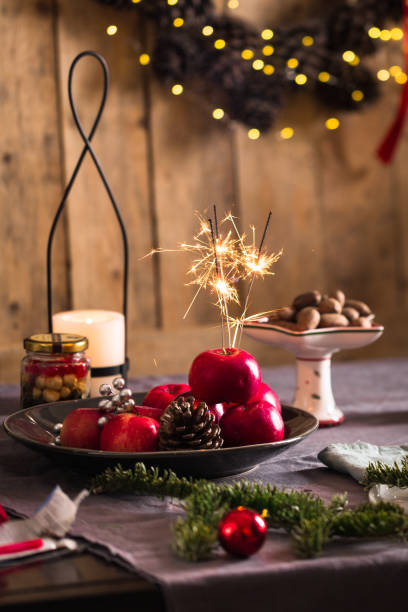 istock Decorated Christmas or New year dinner table setting, wooden wall with pine cone wreath, bokeh background, basket of fir branches 1190010845