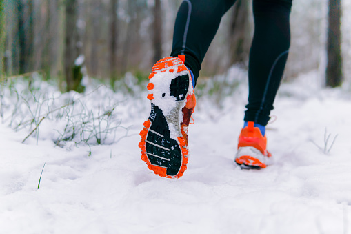 runner legs while jogging in winter closeup