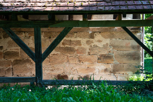 Close up of a stone shelter with timber frame in green nature