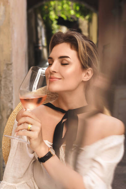 giovane donna beve vino rosa nel bar di strada - vino rosato foto e immagini stock