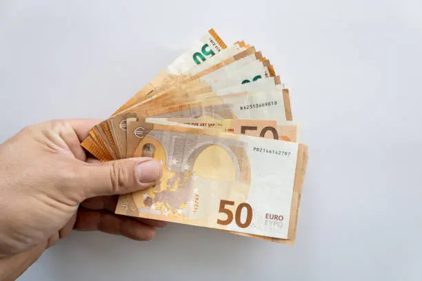 50 euros banknotes held in hand on white background