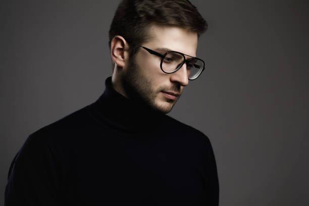 Portrait of young smart man wearing glasses and a folded polo neck
