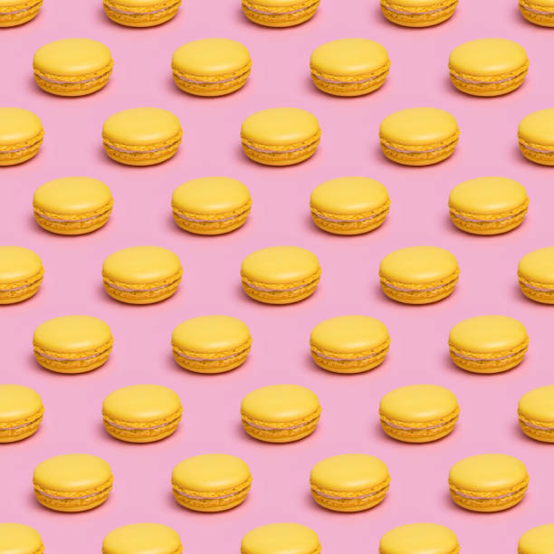 istock Seamless pattern with yellow macaron cookies on a pink background. 1190023561