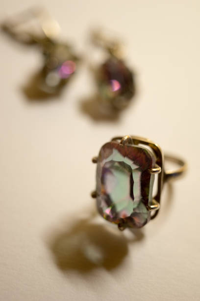 istock Silver ring and earrings with a big stone mystic topaz on a white table. 1190025218