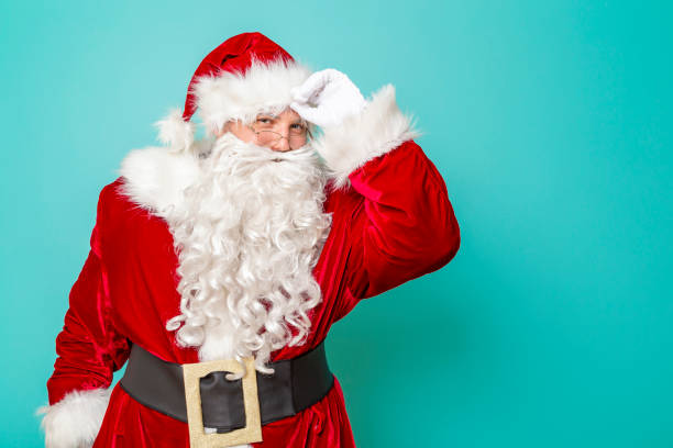 istock Santa Claus greeting people by touching his hat 1190026117