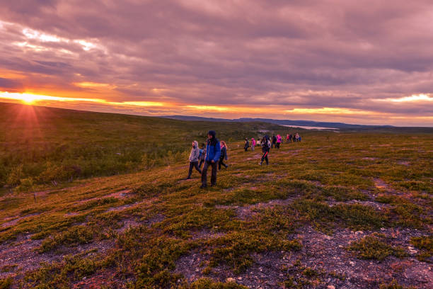 vandrare följer leden i kautokeino-regionen i norska finnmark. tundran och sjölandskapet i solnedgången lyser i bakgrunden. - same direction bildbanksfoton och bilder