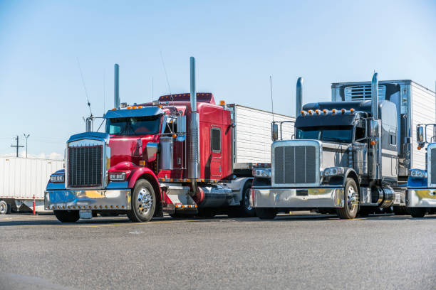 classic bonnet big rigs semi trucks with reefer semi trailers standing in row on truck stop parking lot waiting for delivery schedule - semi truck fotos imagens e fotografias de stock