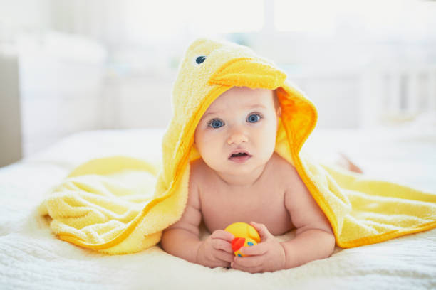 istock Cute little girl playing with rubber duck after having bath 1190030855
