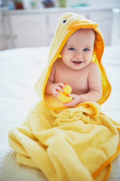 istock Cute little girl playing with rubber duck after having bath 1190030865