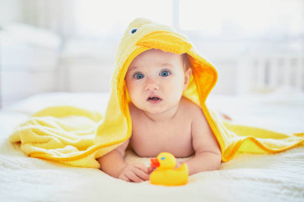 istock Cute little girl playing with rubber duck after having bath 1190030877